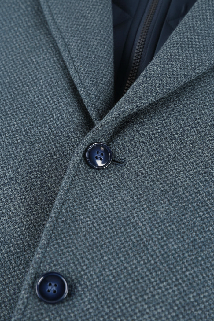 Coat windvanger melange blauwgrijs close-up of buttons on a textured fabric, windproof design.
