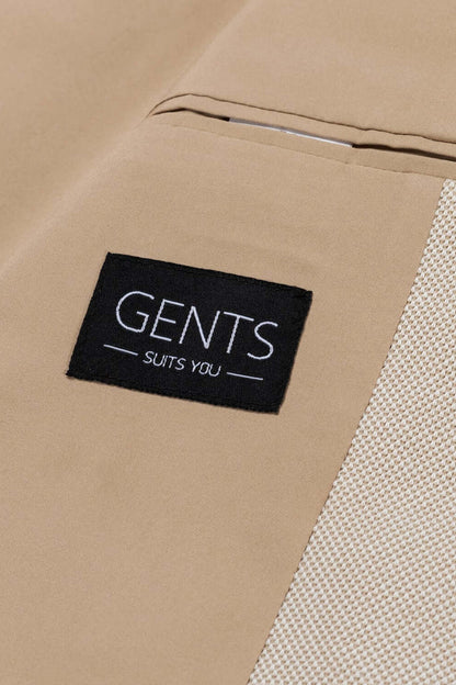 Label of a Colbert stretchkatoen zand showing brand GENTS SUITS YOU on a beige background.