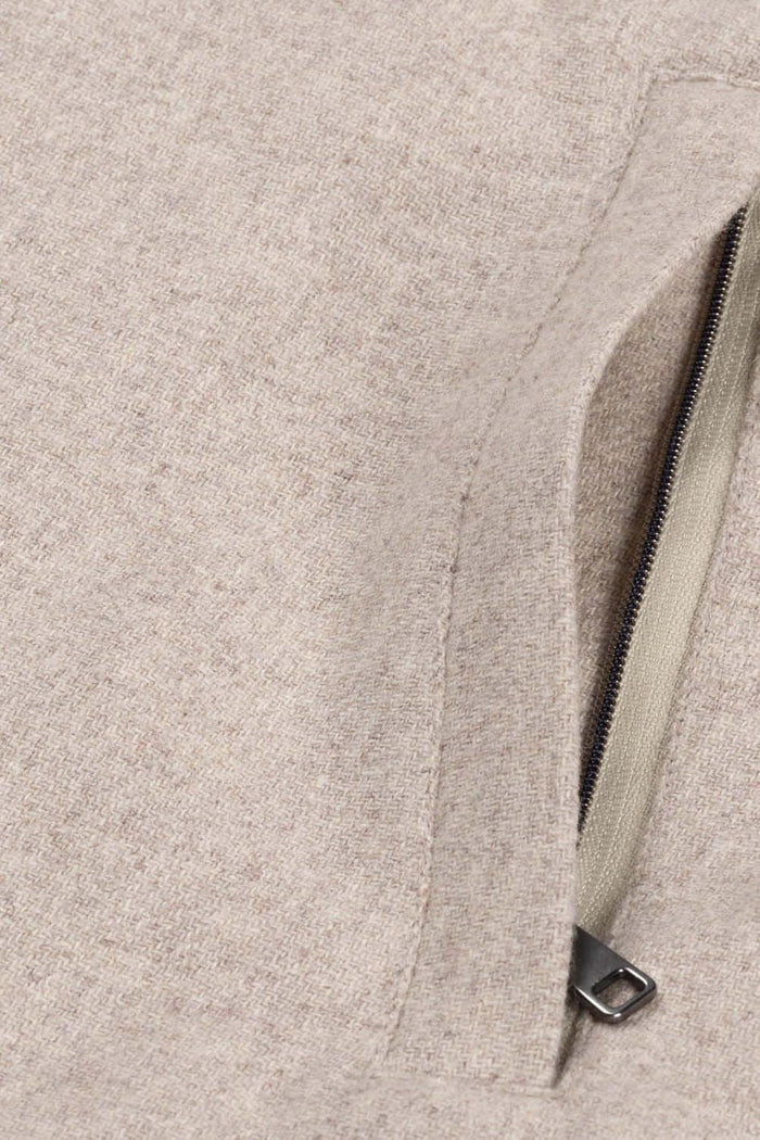 Detail of the zipper on a full-zip cardigan zandbeige, showcasing the fabric texture and color.