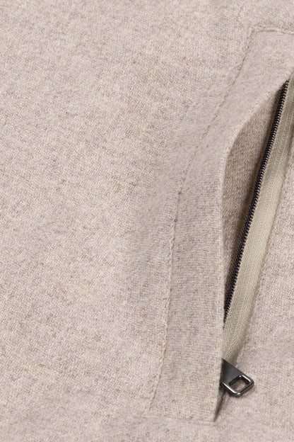 Detail of the zipper on a full-zip cardigan zandbeige, showcasing the fabric texture and color.