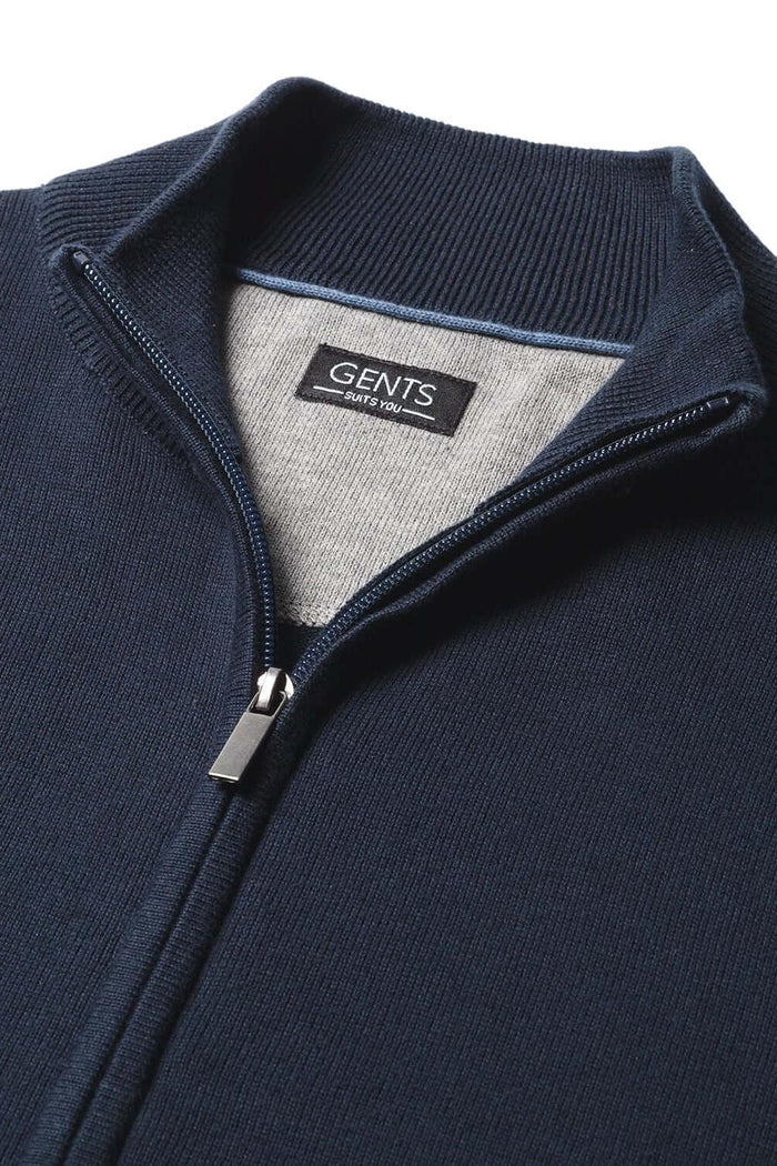 Close-up of a full zip navy cotton jacket with smooth zipper detail and label.