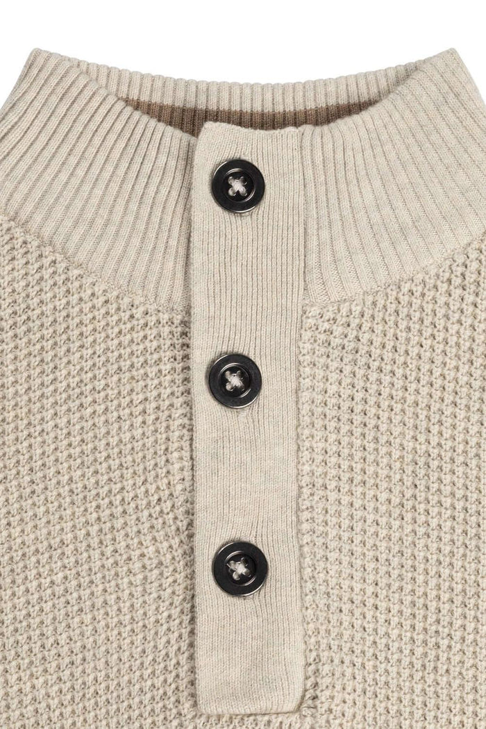 Half zip-knopen structuur ecru met details van zwart knopen en ribgebreide kraag.