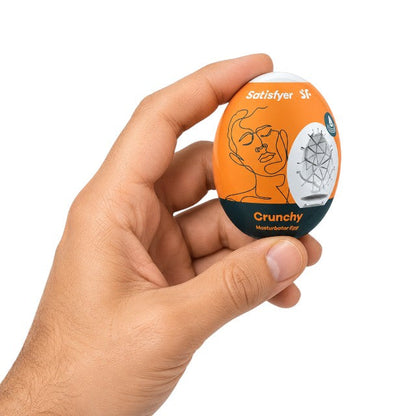 Ou masturbator SATISFYER Crunchy Egg, de unică folosință, interior texturat, material flexibil TPE (portocaliu)&nbsp;