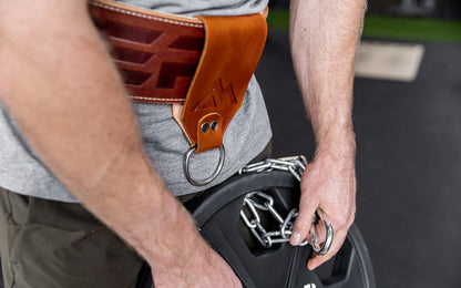 Athlete using the chain and carabiner to attach a 45lb plate to his REP Leather Utility Loop.