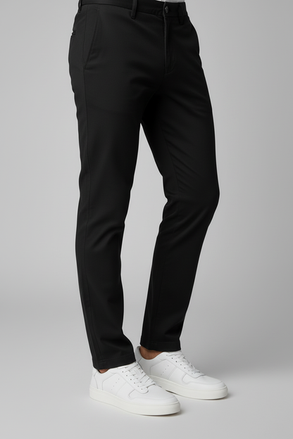 Man wearing black pants and Sneaker leder wit on a gray background.