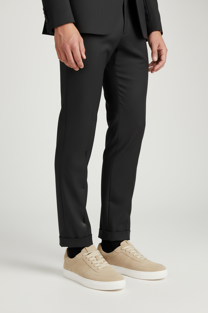 Sneaker suede zand worn with black suit, showcasing stylish and breathable comfort in zandkleurige suède design.