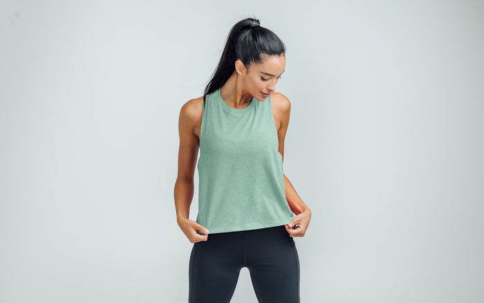 The REP Fitness Women's Peak Cropped Dual-Blend Tank in Heather Sage/Sage on body