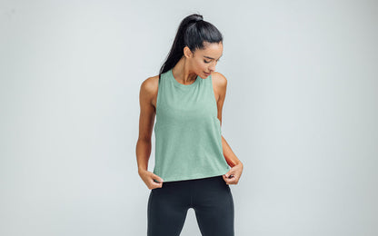 The REP Fitness Women's Peak Cropped Dual-Blend Tank in Heather Sage/Sage on body